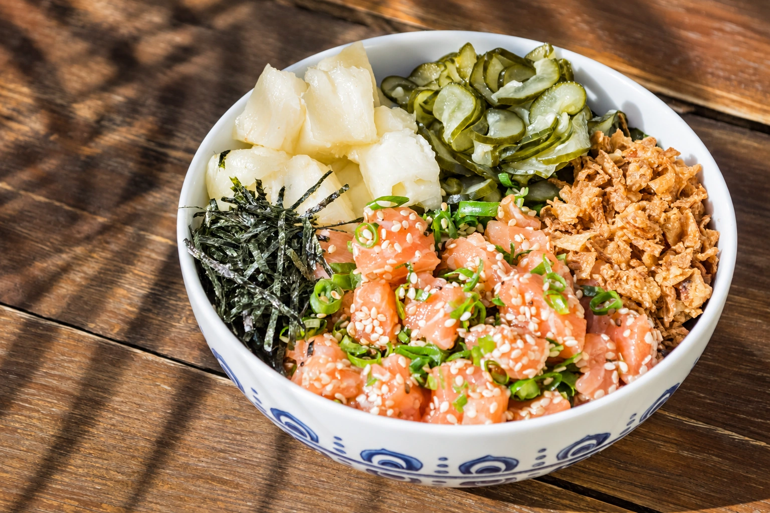 Poke de salmão com pepino, nori, gergelim, cebolinha e acompanhamentos.